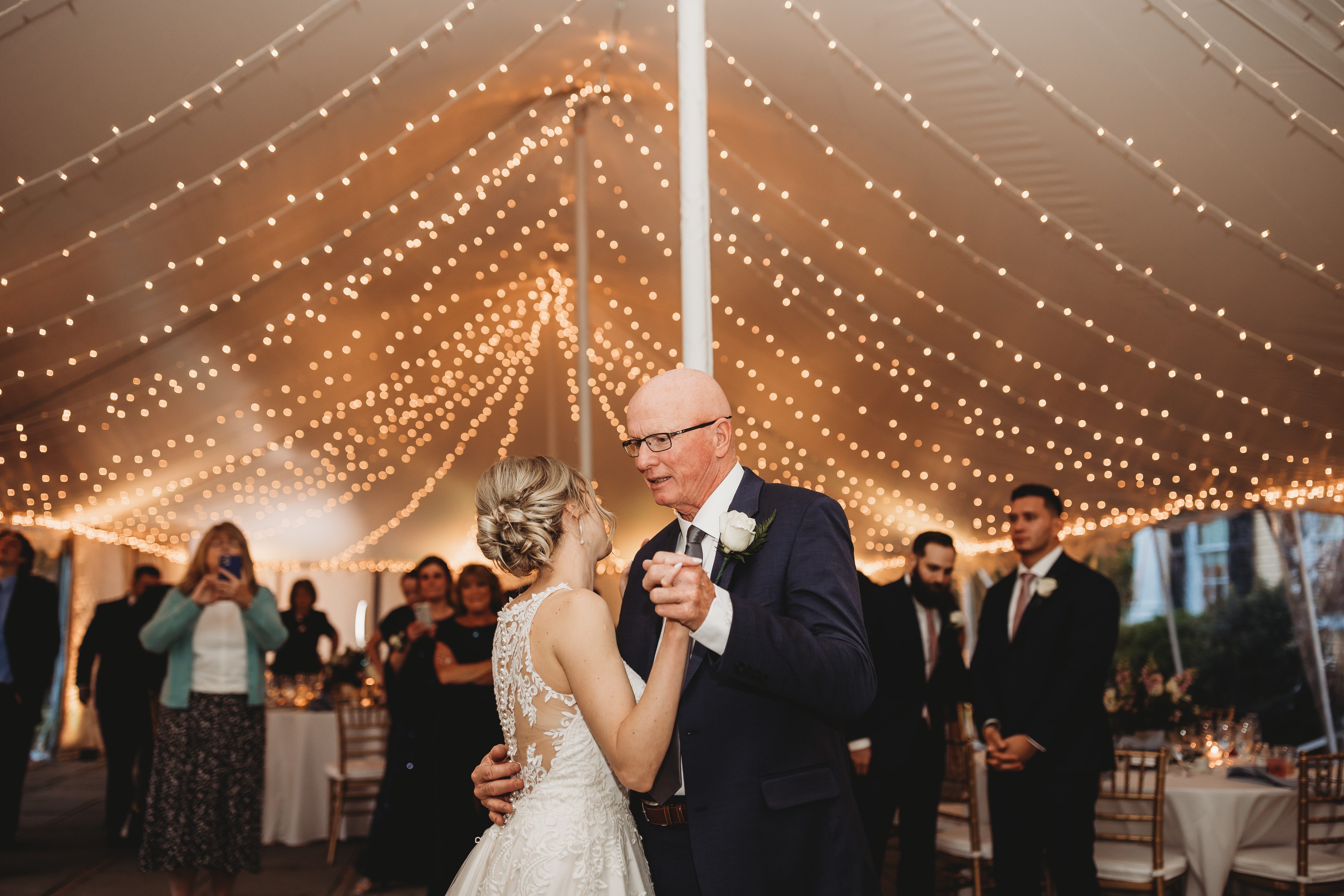 Father-daughter dance under warm bistro string lights at a New England wedding reception