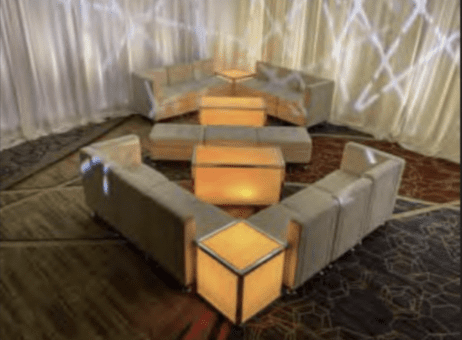 White curved VIP lounge seating pod with side tables at a Boston wedding venue