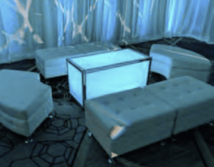 Coordinated lounge furniture grouping with sofa, chairs, and coffee table at a New England gala