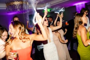 Color-changing uplights enhancing energy during packed wedding dance floor