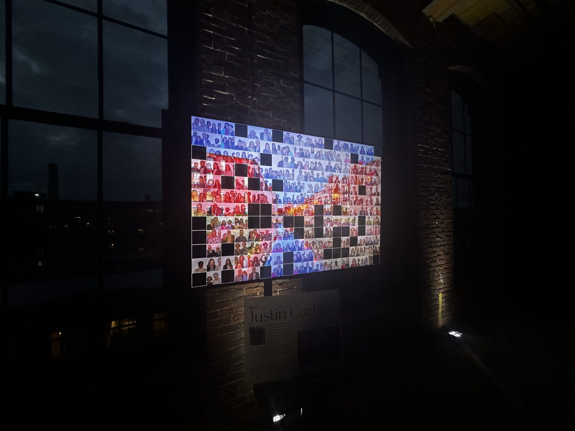 Event guests gathered around the digital mosaic photo booth display during a wedding reception