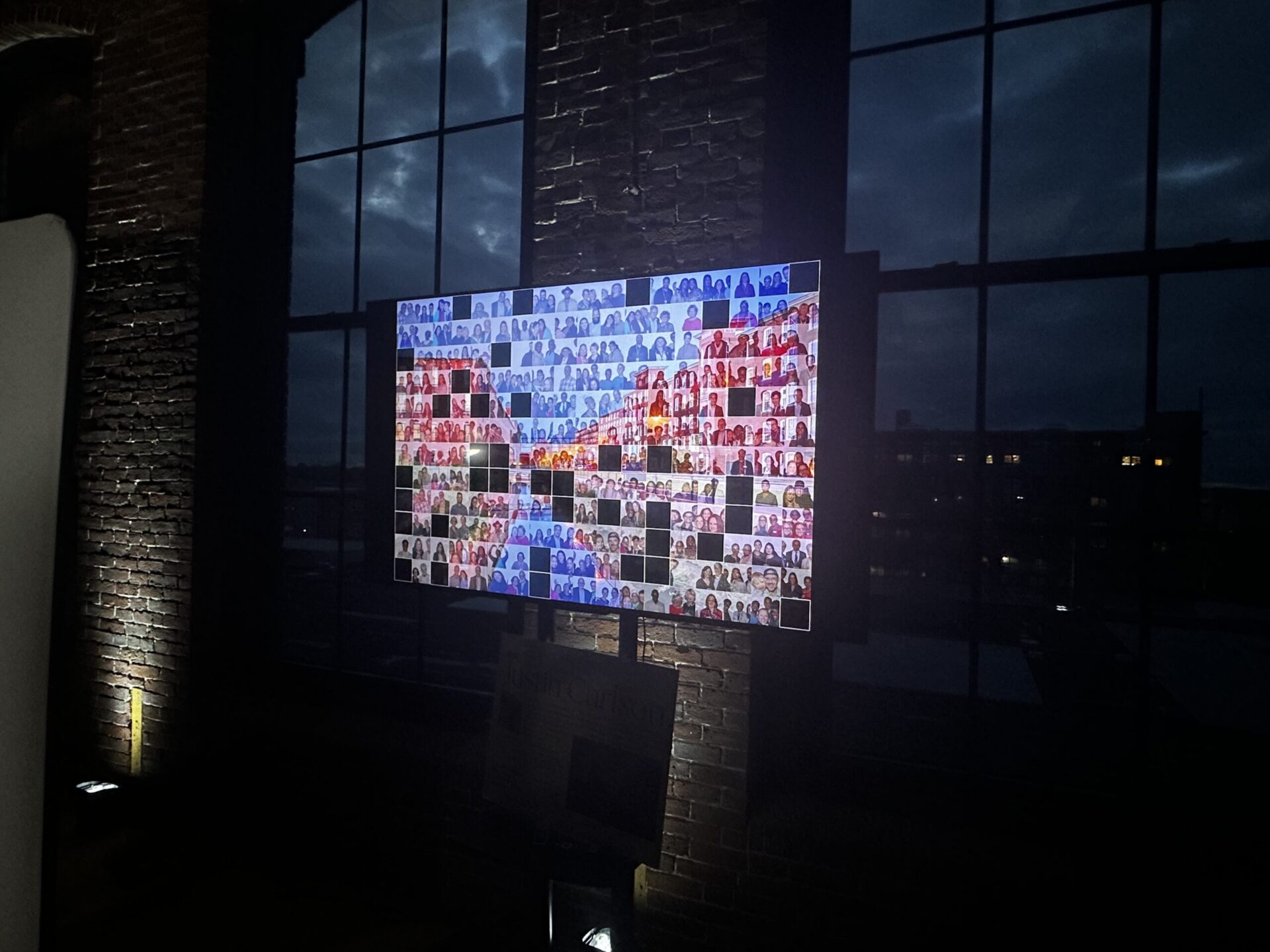 Digital mosaic photo booth display building live at a Boston event, mosaic tiles filling in on large screen